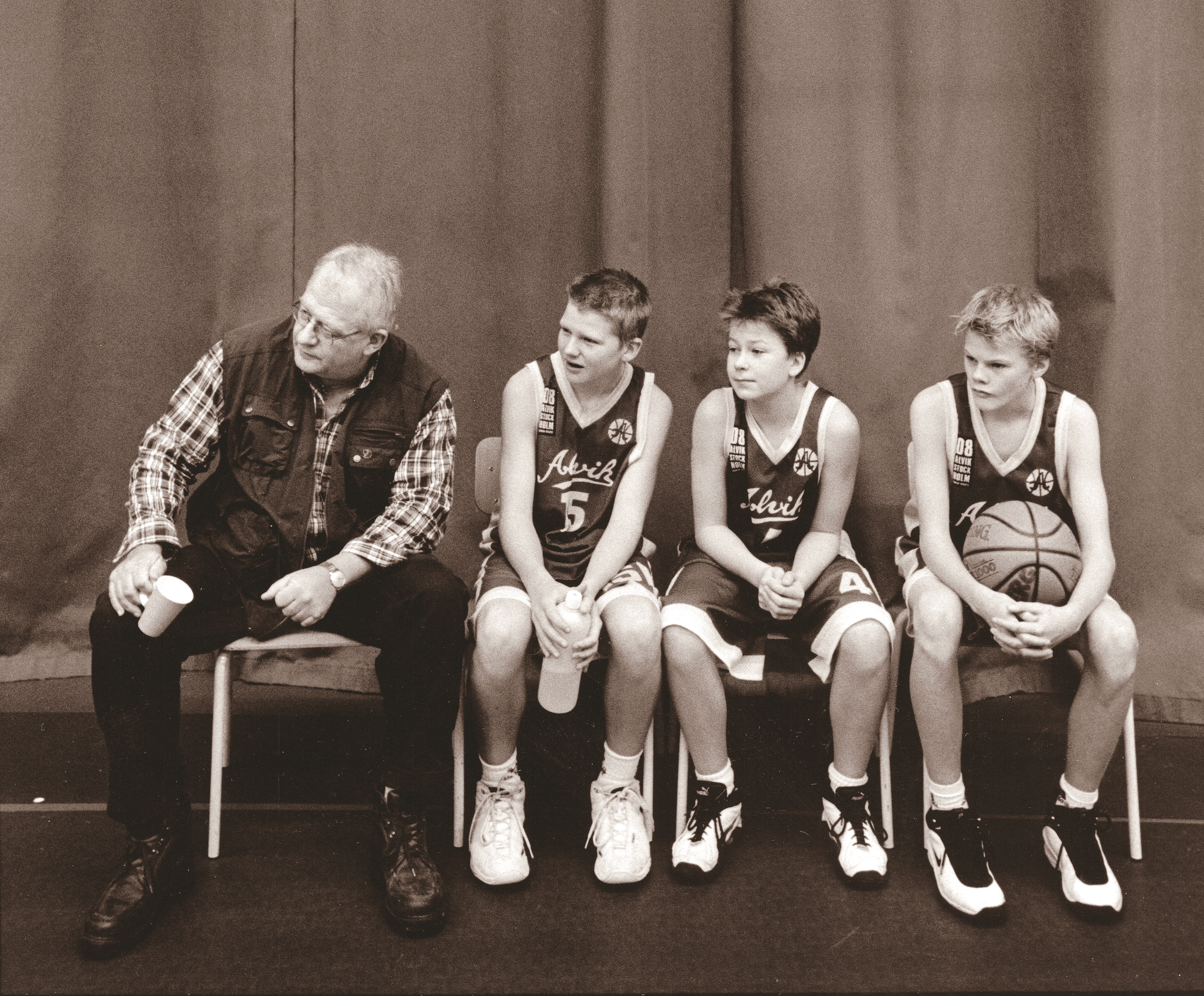 Fryshusets grundare Anders Carlberg med tre unga basketspelare