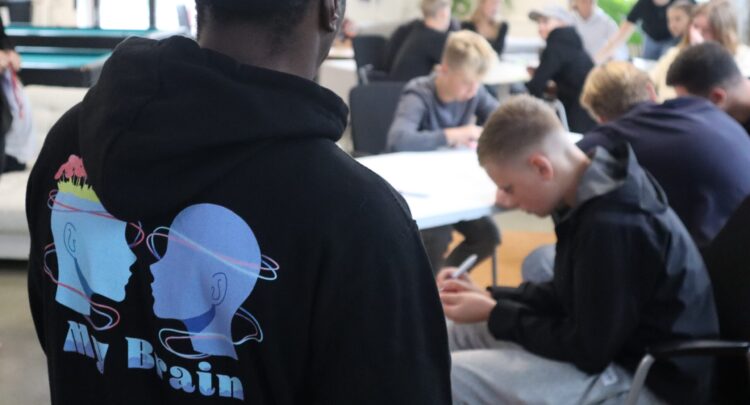 Bild på utbildare med MyBrain-hoodie, som vägleder unga som arbetar med MyBrain.